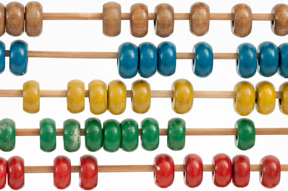 Rows of wooden abacus beads in blue, yellow, green, and red