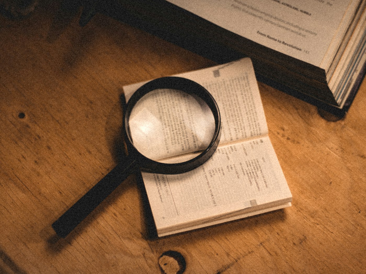 A magnifying glass resting on an open book, a metaphor for tracing an extracted field back to its source sentence