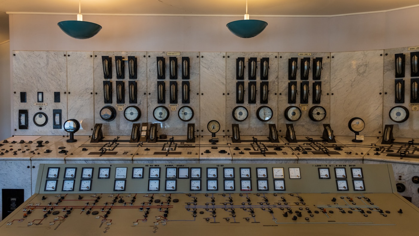 A wall of analog gauges and dials in an industrial control room, the kind of instrument panel a sensor log stands in for