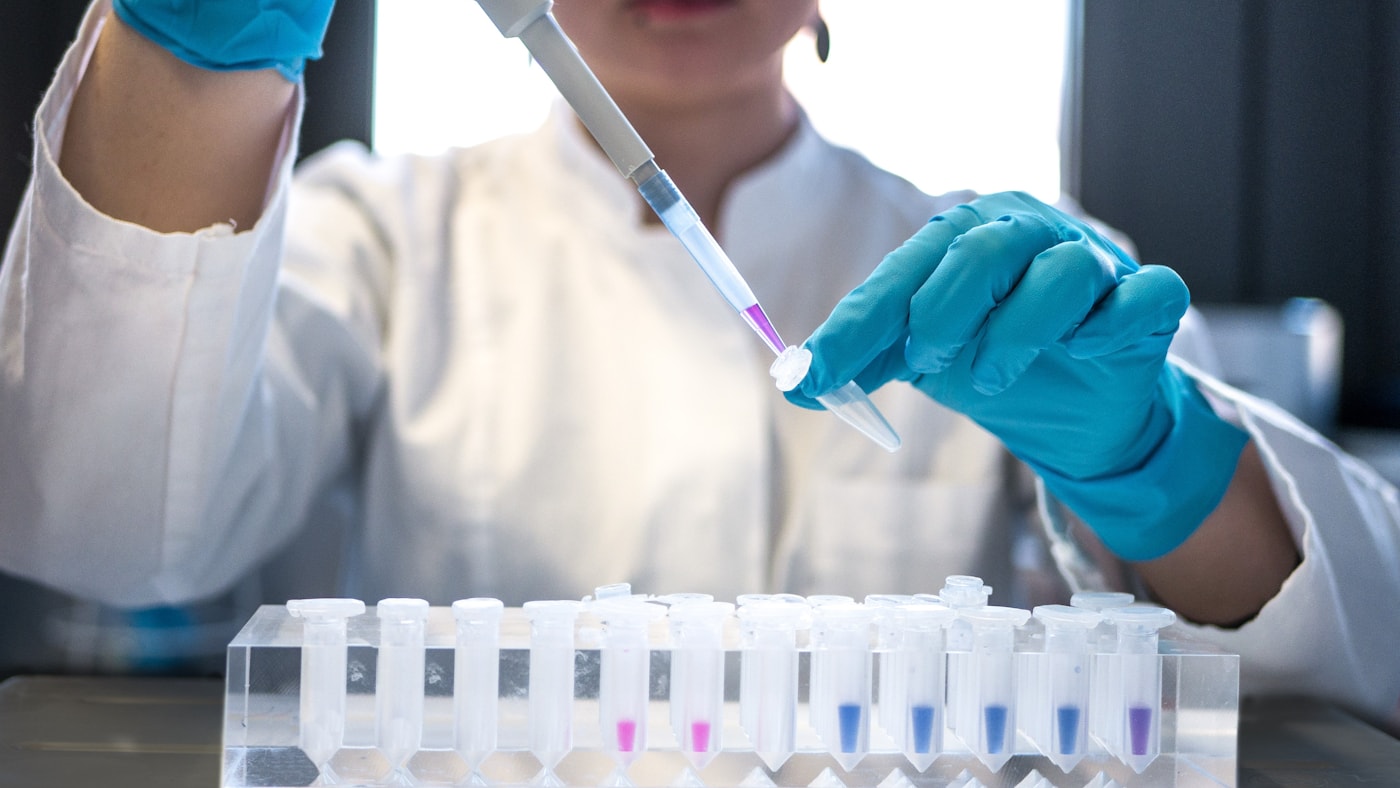 A researcher pipetting samples in a genetics lab, where sequence annotation turns a strand of bases into a typed row