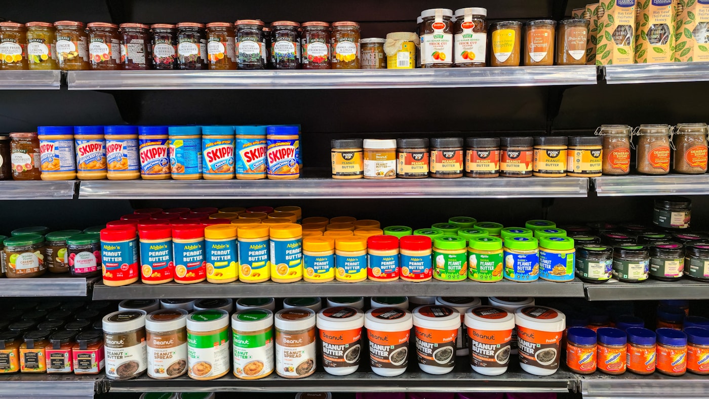 A grocery shelf stocked with rows of labeled jars, the kind of photo a vision model reads into sku, price, and facing count