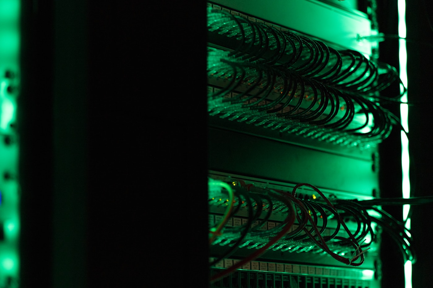 A server rack of dark electronic equipment, tier after tier receding into the frame