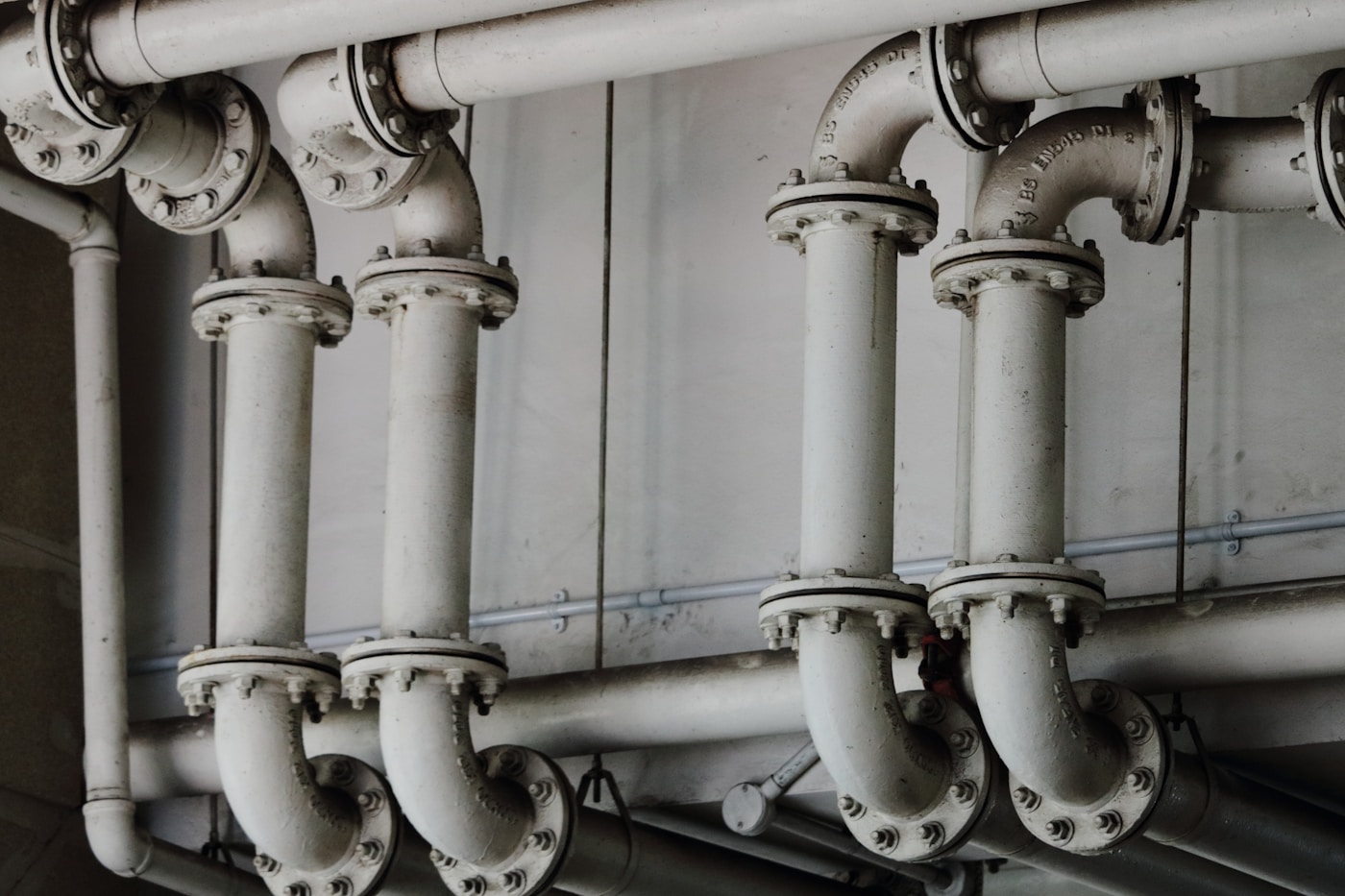 Large grey metal pipes running along a wall, a metaphor for memory bandwidth as the width of the channel feeding a processor